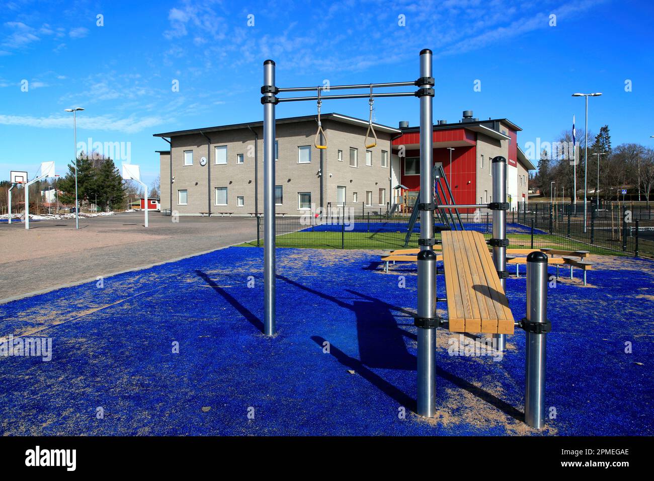 Die moderne Grundschule Kirkonkylän koulu und der Sportplatz mit Fitnessgeräten im Freien. Perniö, Salo, Finnland. 9. April 2023. Stockfoto