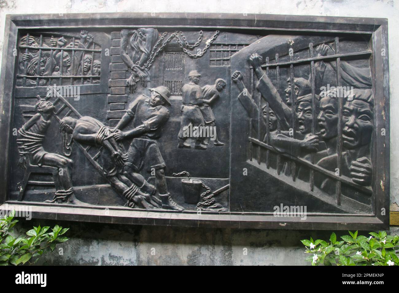 Vietnam: Basrelief, das Folter und Brutalität der französischen Kolonialisten im Gefängnis zeigt, Hoa Lo Gefängnismuseum (alte französische Maison Centrale); Stockfoto