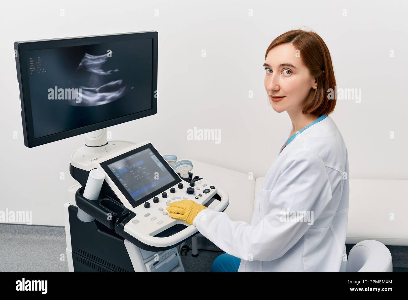 Porträt eines weissen Ultraschallspezialisten in der Nähe einer Ultraschallmaschine an der Medizinischen Klinik. Sonographenberuf Stockfoto