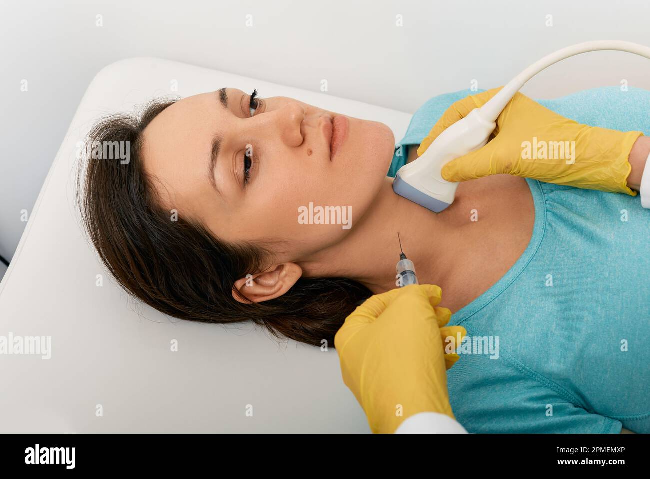 Die Schilddrüsenknotenbiopsie. Erwachsene Frau bei Feinnadelaspirationsbiopsie-gesteuerter Ultraschall- und Ultraschallspezialistin Stockfoto