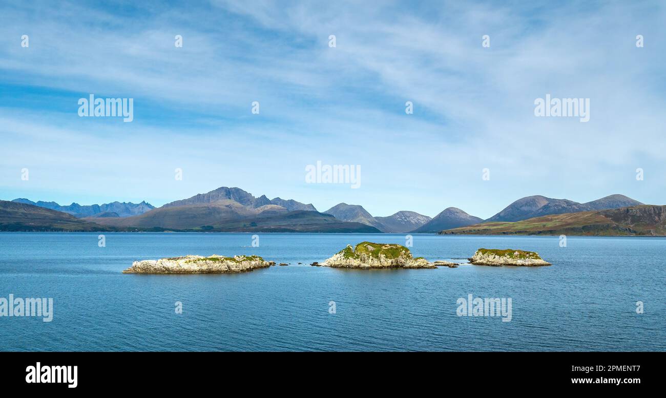 Die drei winzigen Inseln Eilean Ruairidh in Loch Eishort mit den Cuillin-Bergen in der Ferne, aus Sicht von Tokavaig, Isle of Skye, Schottland Stockfoto