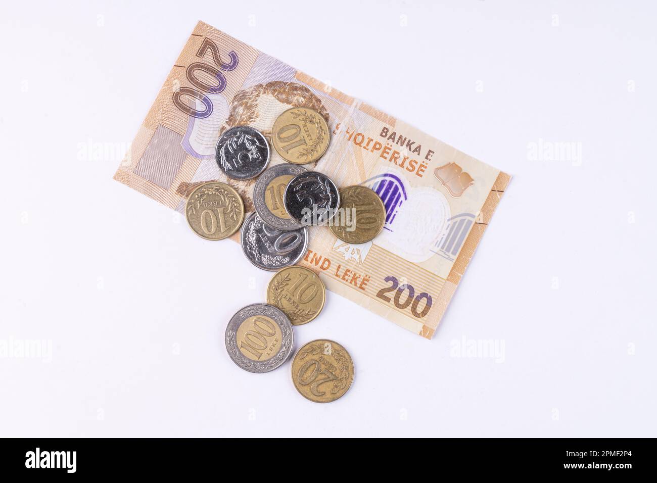 Einige Münzen und eine Lek-Banknote albanischer Währung auf einer weißen Oberfläche Stockfoto