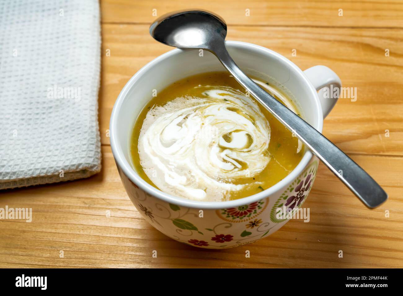 Hausgemachte vegetarische Zucchini-Suppe mit Blaukäse in einer weißen Schüssel auf einem alten, braunen Holztisch Stockfoto