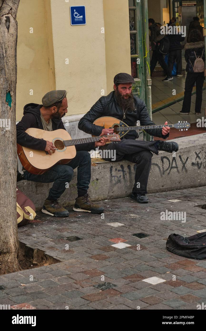 Zwei männliche Gitarrenspieler, die in Plaka, Athen, Griechenland rumvögeln Stockfoto