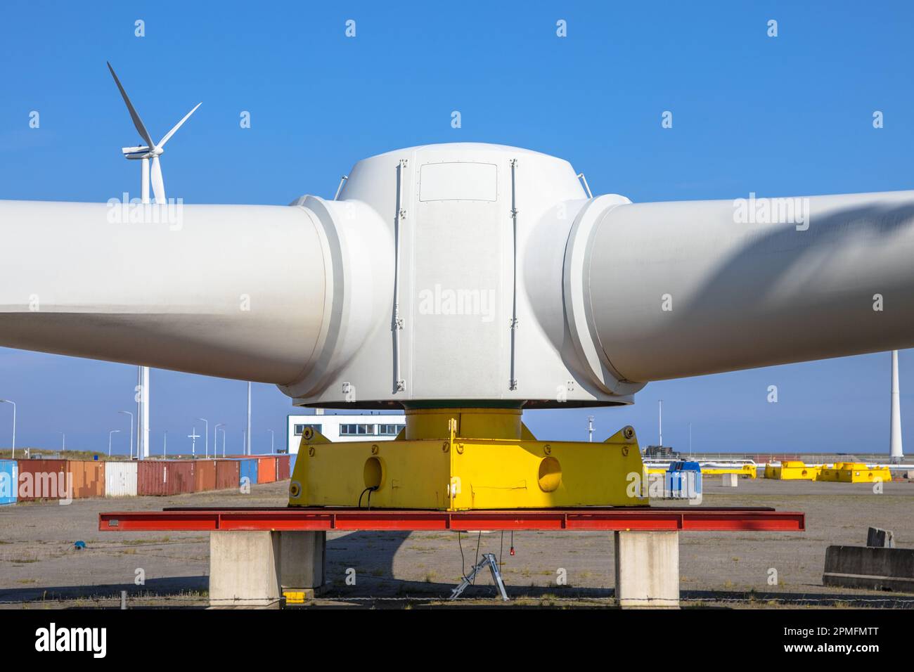 Riesige Rotoren aus Windturbinen auf einem Windmühlen-Bauhof, um Windfarmen auf See unter blauem Himmel zu bauen Stockfoto