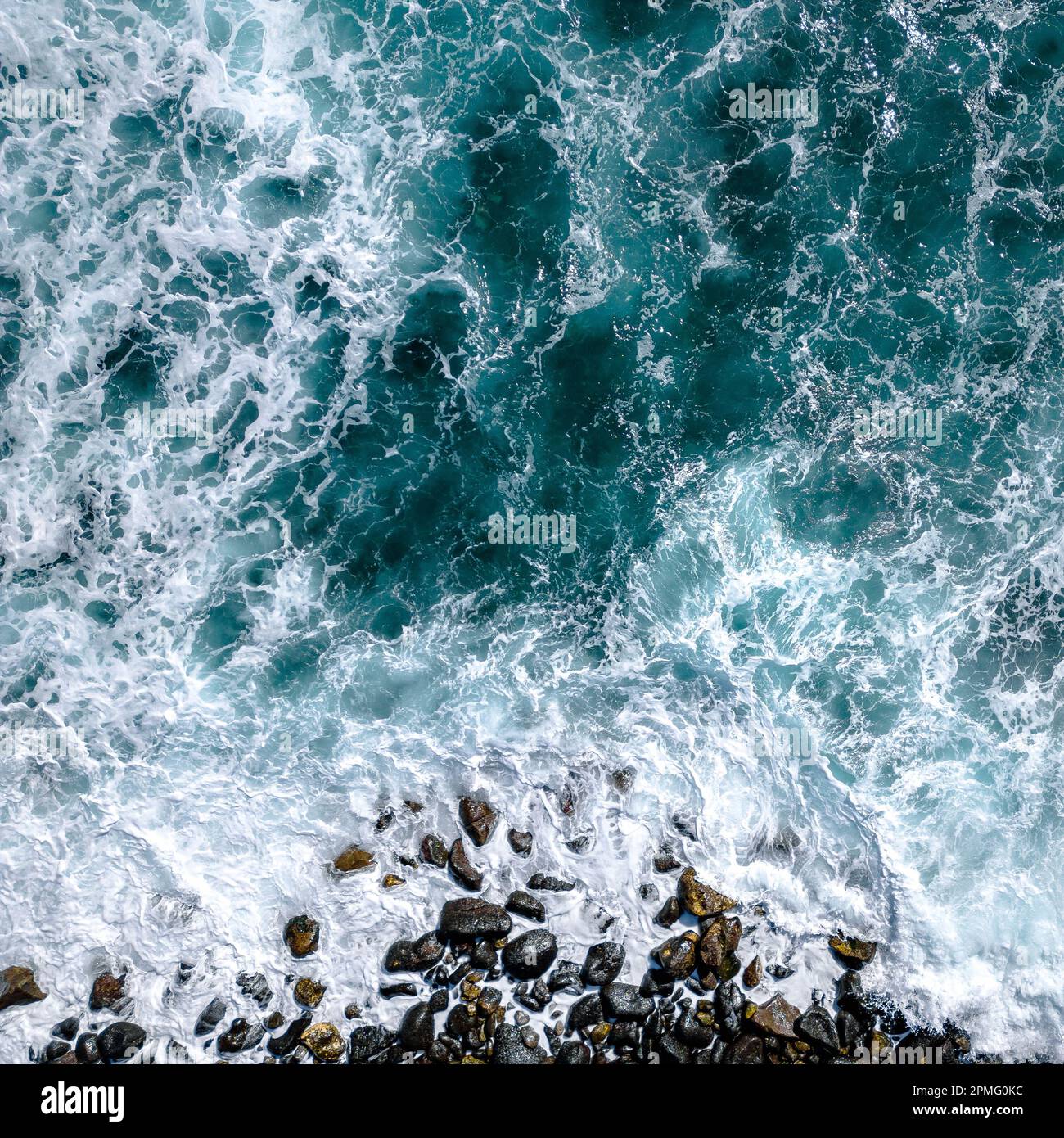 Luftaufnahme zu den Ozeanwellen. Blauer Hintergrund. Draufsicht auf das schäumende Wasser des Blauen Ozeans. Stockfoto