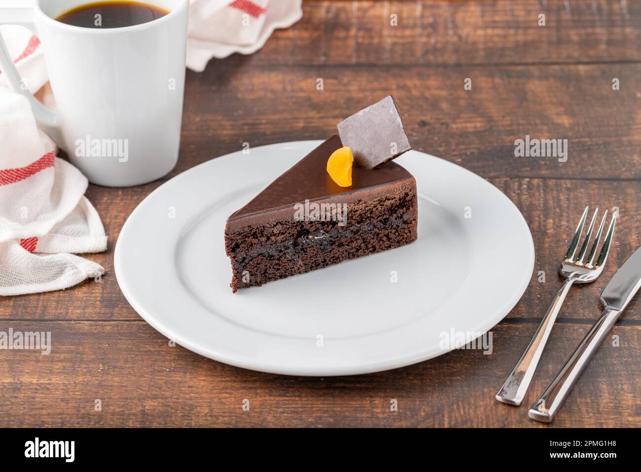 Orangen- und Schokoladenkuchen mit einer Tasse Kaffee auf einem Holztisch Stockfoto