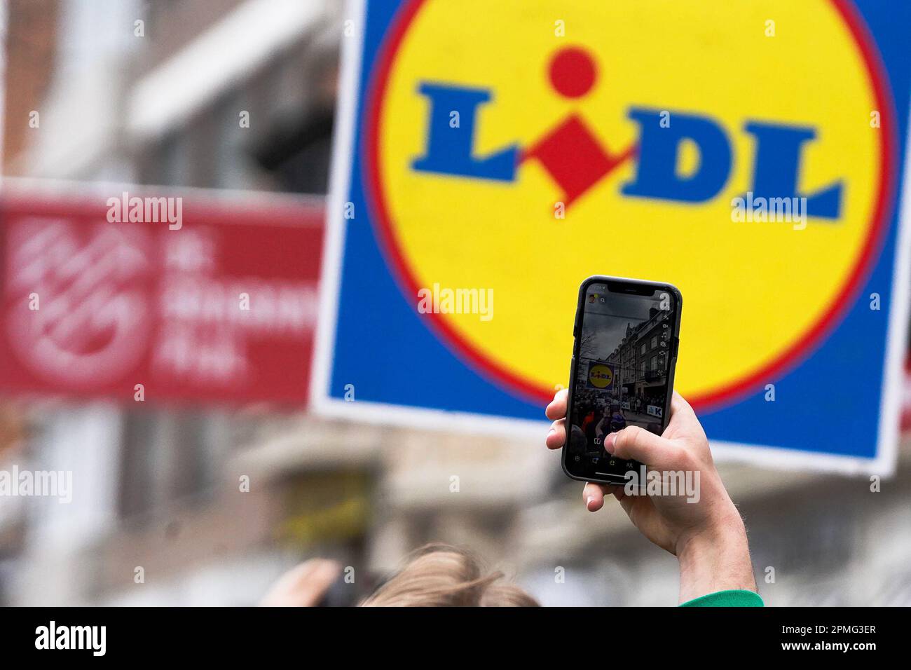 Overijse, Belgien. 12. April 2023. Die Abbildung zeigt eine Zuschauerin, die zu Beginn in Leuven ein Foto mit ihrem Smartphone mit einem Lidl-Schild auf der Rückseite beim RADRENNEN BRABANTSE PIJL Men macht, 205,1 km von LEUVEN nach OVERIJSE, Mittwoch, den 12. 2023. April. FOTO SPORTPIX | Thijs Wintein Stockfoto