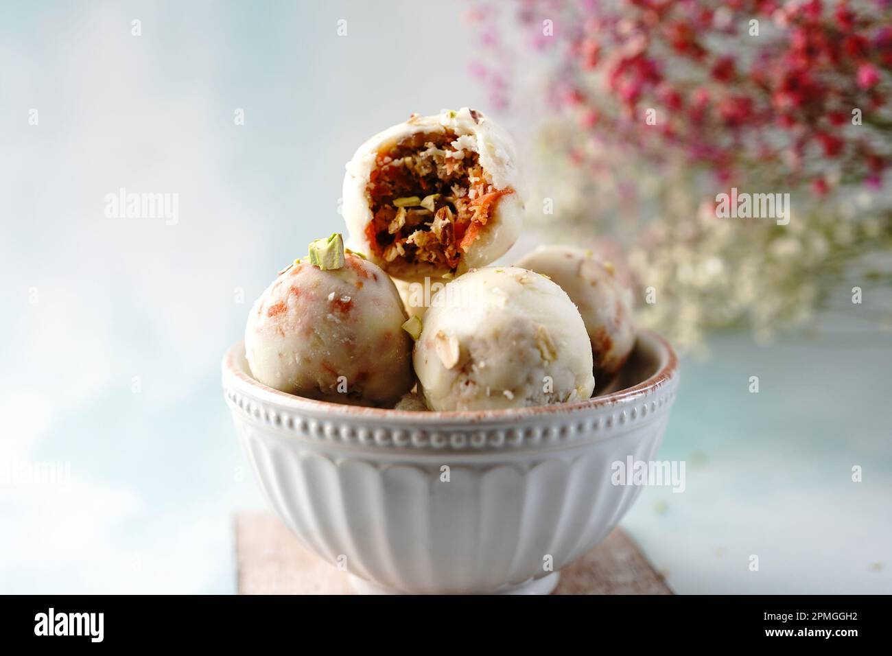 Keine Energiebissen von rohen Karottenkuchen oder Kugeln gefüllt mit Nüssen und mit weißer Schokolade überzogen Stockfoto