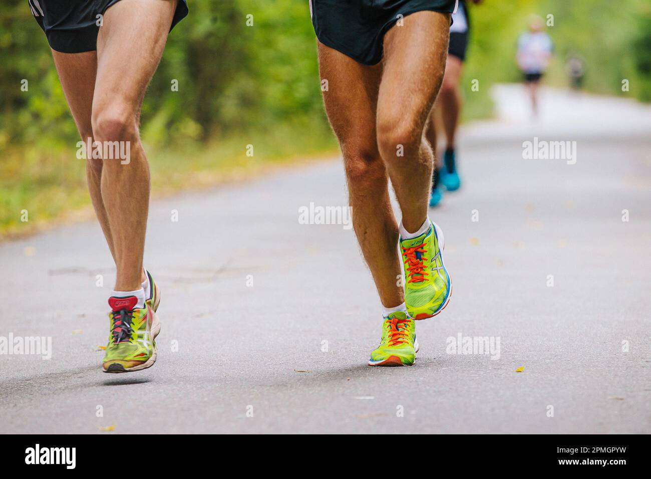 Chelyabinsk, Russland - 11. September 2016: Beine zwei männliche Läufer laufen in Asics Laufschuhen einen Marathon Road Park Stockfoto