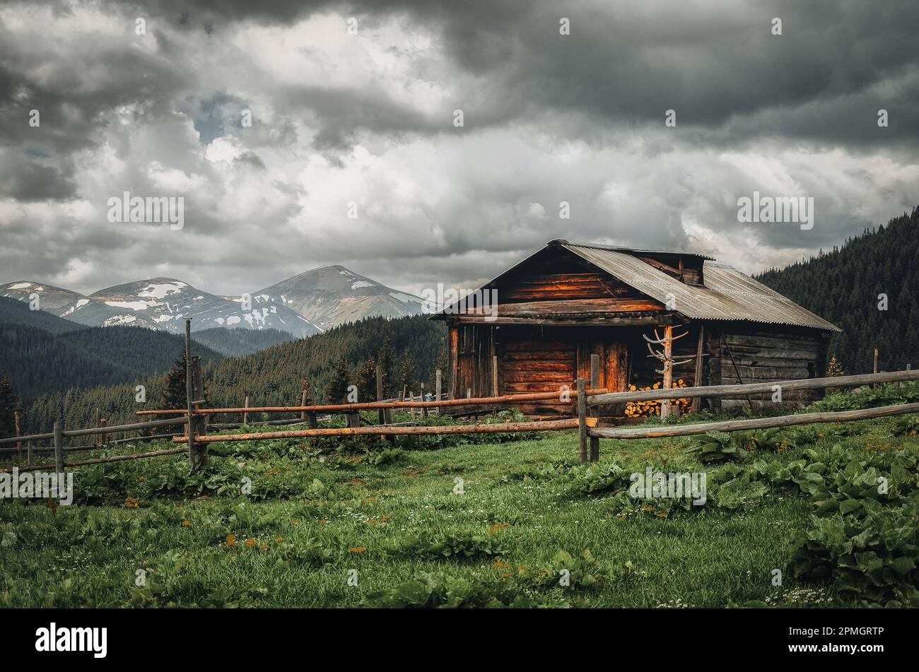 Ein altes Bauernhaus auf einer Bergwiese über den Karpaten. Wunderschöne Wanderlandschaft in der Ukraine. Stockfoto