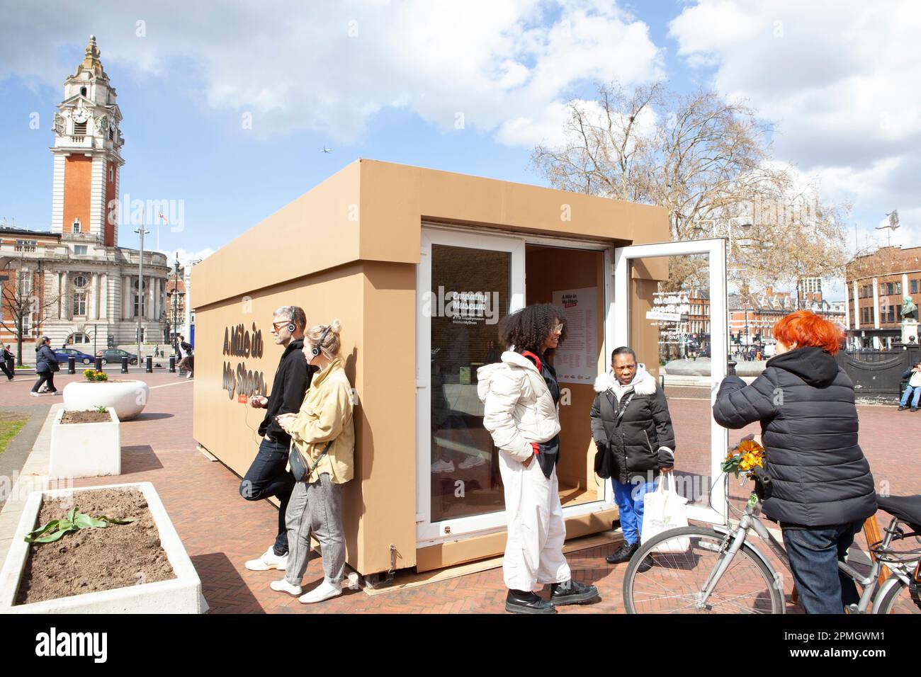 London, UK, 13. April 2023: Am Windrush Square, Brixton, ist ein riesiger Schuhkarton eingetroffen, der eine Pop-up-Ausstellung „Walk a Mile in My Shoes“ am Empathy Museum zeigt. Besucher wählen ein Paar Schuhe und hören sich eine Aufzeichnung des Schuhbesitzers an, in der sie über ihre Erfahrungen mit dem Brixton-Aufstand von 1981 oder anderen Aufständen in Bristol und Liverpool in dieser Zeit sprechen. Anna Watson/Alamy Live News Stockfoto