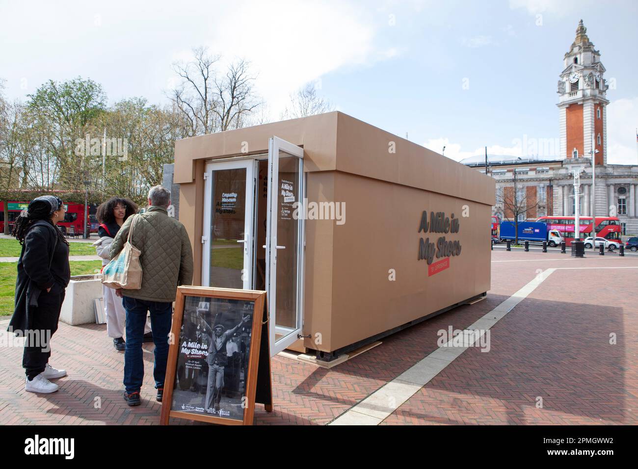 London, UK, 13. April 2023: Am Windrush Square, Brixton, ist ein riesiger Schuhkarton eingetroffen, der eine Pop-up-Ausstellung „Walk a Mile in My Shoes“ am Empathy Museum zeigt. Besucher wählen ein Paar Schuhe und hören sich eine Aufzeichnung des Schuhbesitzers an, in der sie über ihre Erfahrungen mit dem Brixton-Aufstand von 1981 oder anderen Aufständen in Bristol und Liverpool in dieser Zeit sprechen. Anna Watson/Alamy Live News Stockfoto