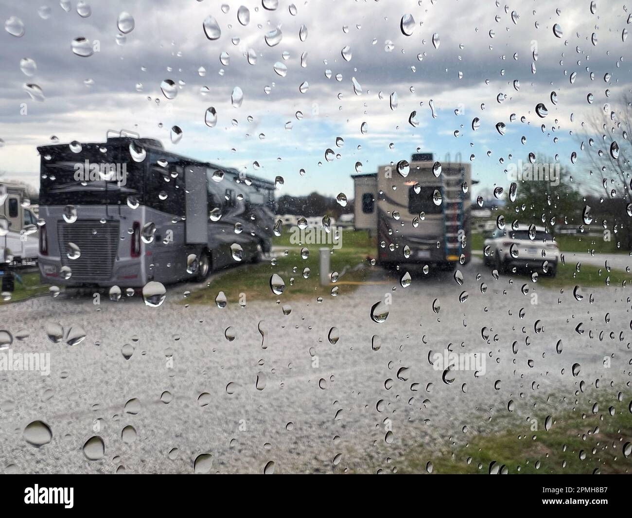 Ein regnerischer Tag auf dem Campingplatz mit Blick auf luxuriöse Freizeitfahrzeuge. Stockfoto