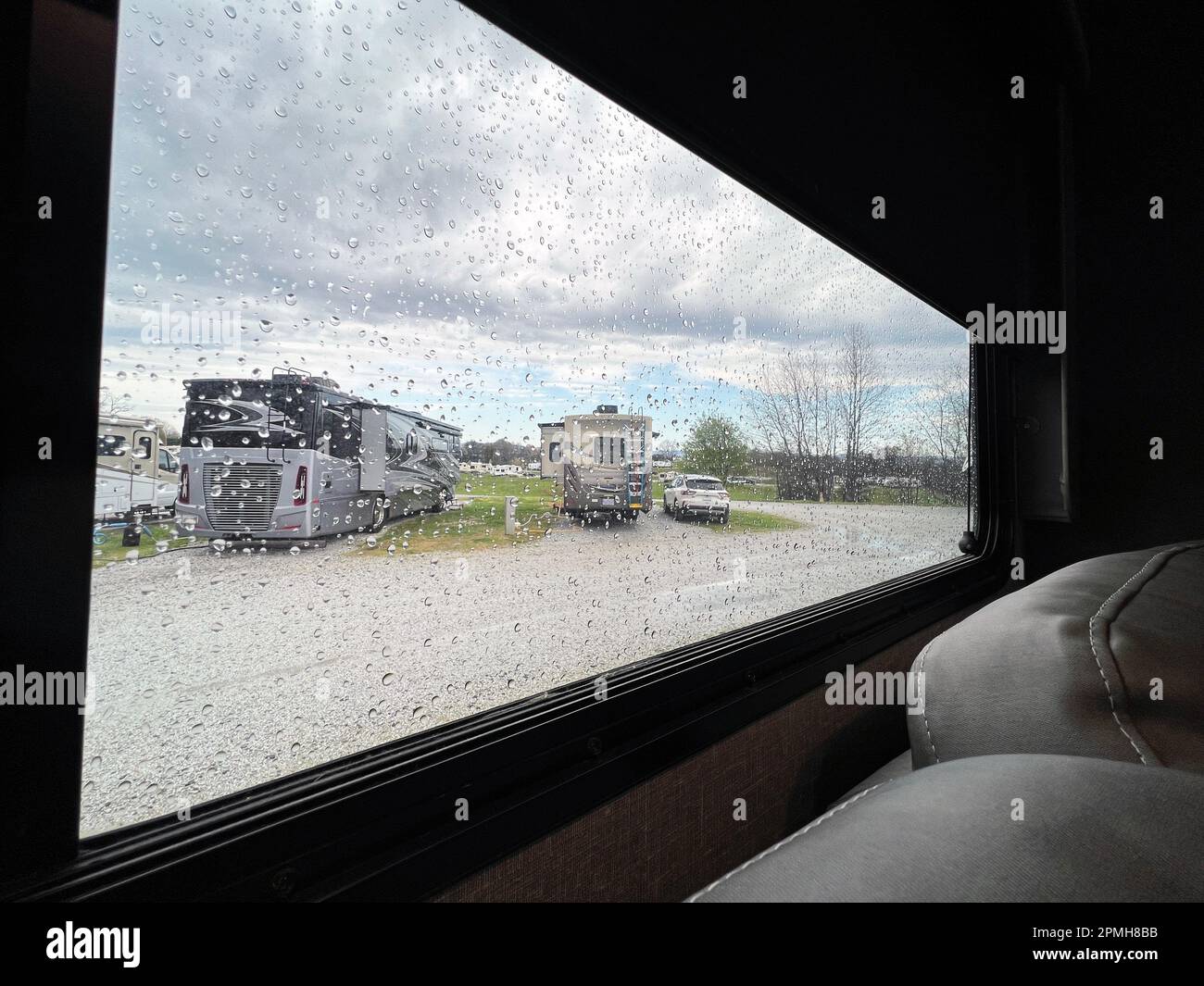 Ein regnerischer Tag auf dem Campingplatz mit Blick auf luxuriöse Freizeitfahrzeuge. Stockfoto