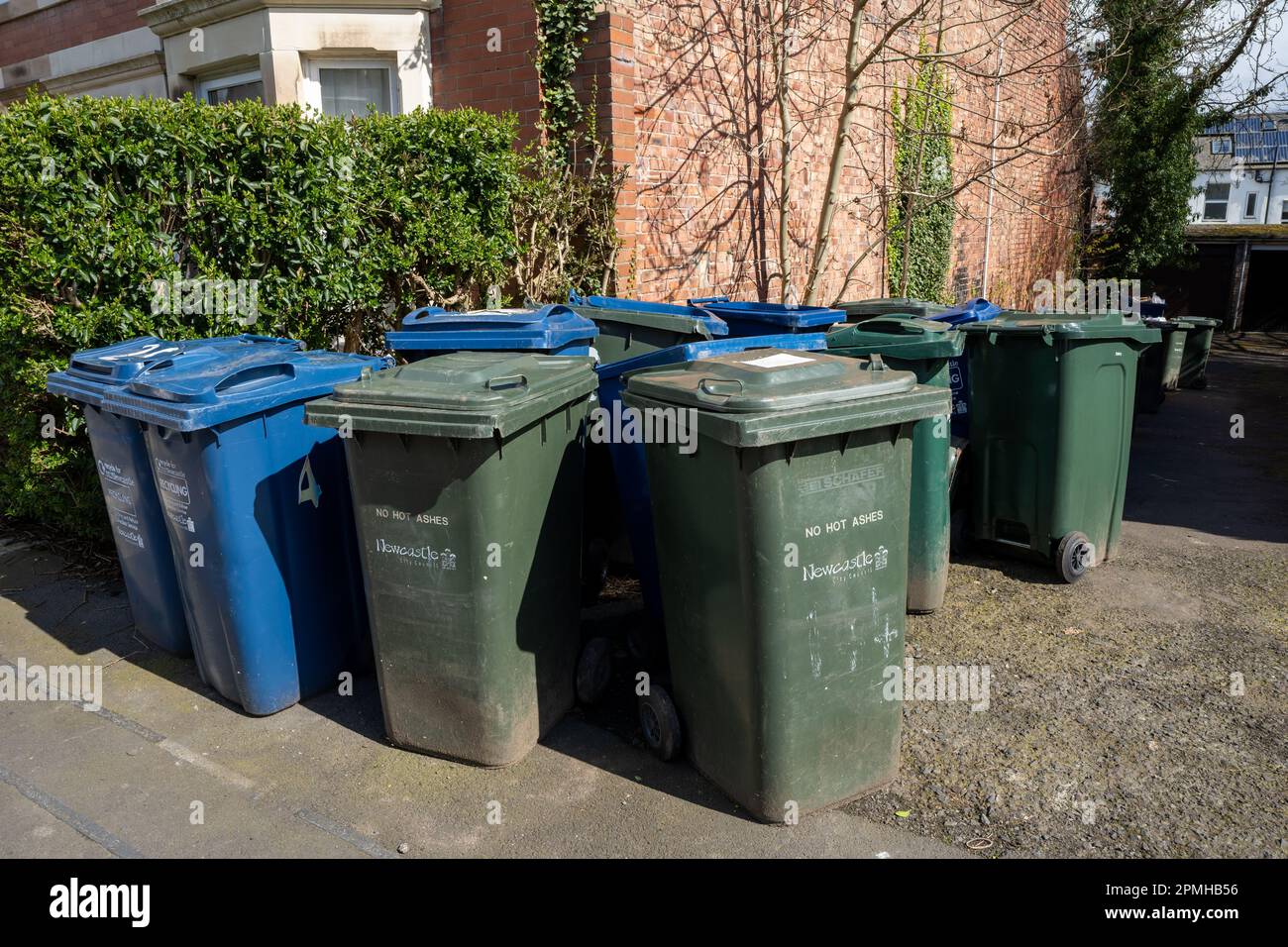 Eine Gruppe grüner allgemeiner Abfälle und blauer Recyclingbehälter an einer Straßenecke in Newcastle upon Tyne, Großbritannien. Stockfoto