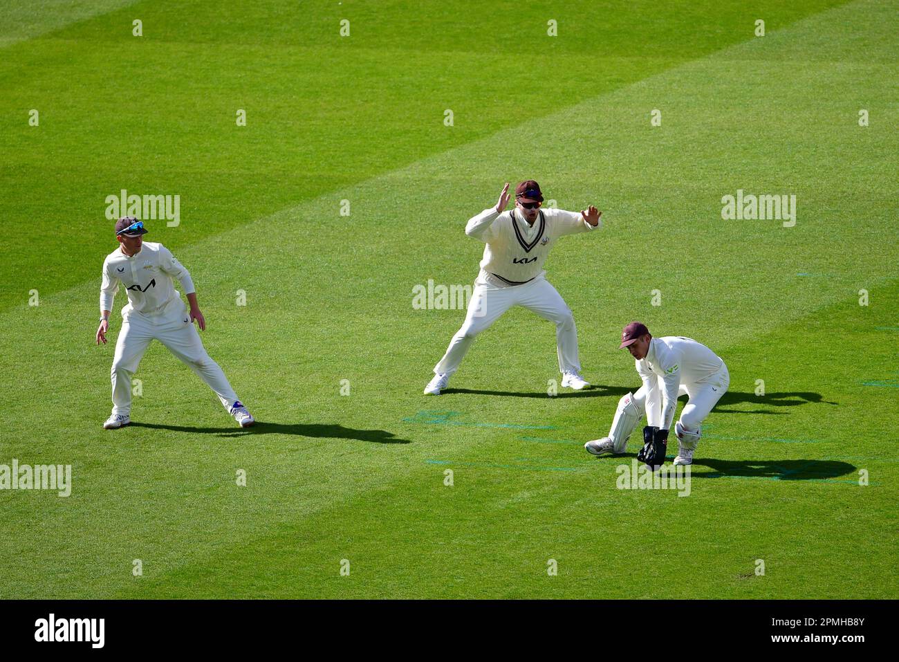 Das Kia Oval, London, Großbritannien. 13. April 2023. Jamie Smith aus Surrey spielt hinter den Baumstümpfen einen Ball, während Ollie Pope (links) und Dom Sibley (Mitte) am 1. Tag des Spiels LV=Insurance County Championship Division One zwischen Surrey und Hampshire schauen: Credit: Ashley Western/Alamy Live News Stockfoto