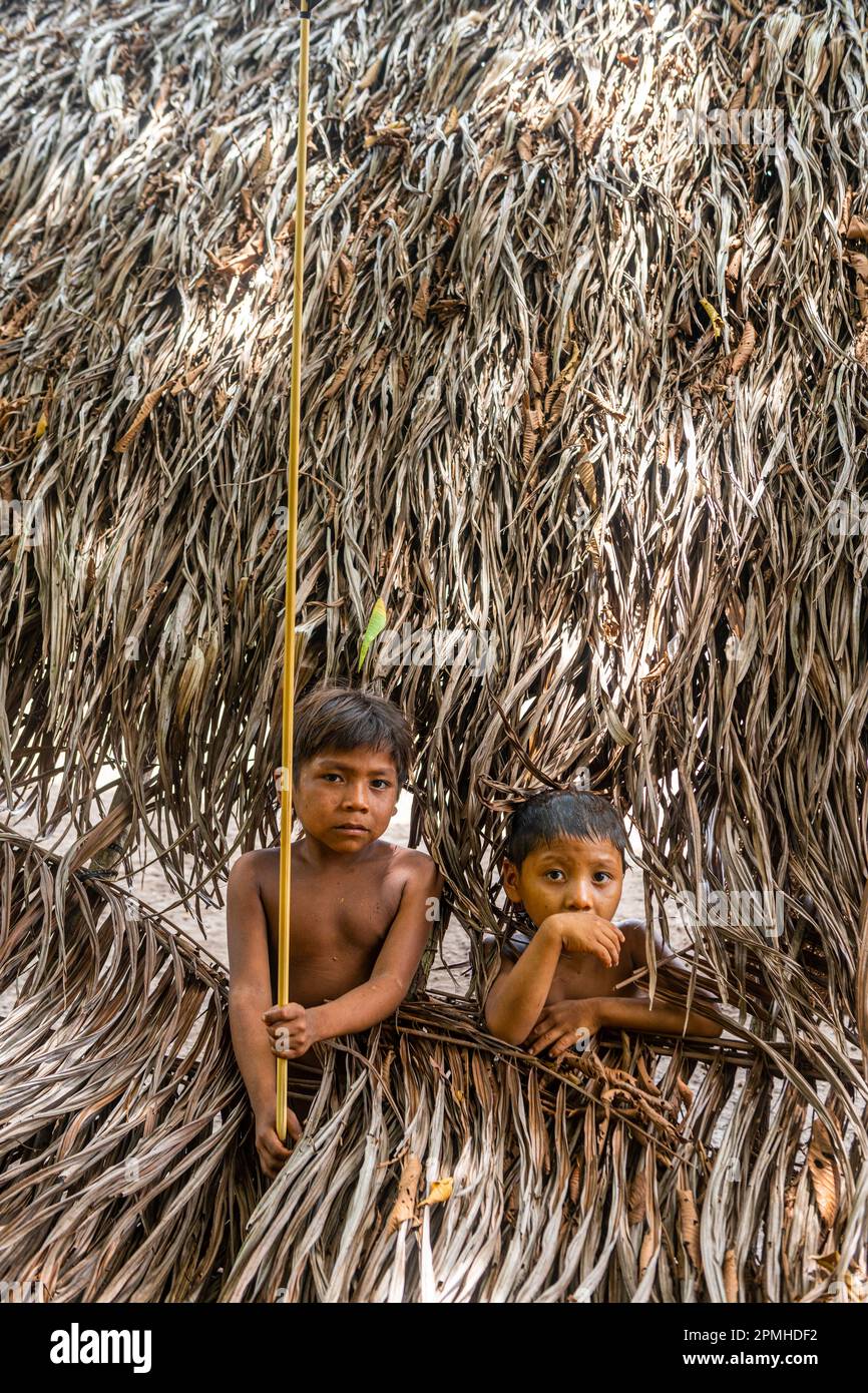 Junge Jungs, die durch ein Loch schauen, Yanomami-Stamm, Süd-Venezuela, Südamerika Stockfoto