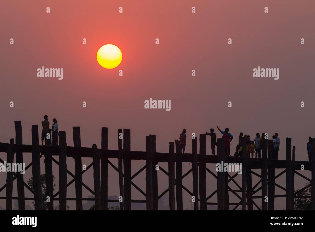 Menschen, die auf der U-Bein Brücke über den Taung Tha man See bei Sonnenuntergang laufen, Amarapura, Mandalay, Myanmar (Birma), Asien Stockfoto