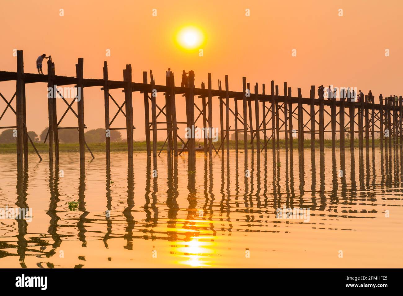 Menschen, die auf der U-Bein Brücke über den Taung Tha man See bei Sonnenuntergang laufen, Amarapura, Mandalay, Myanmar (Birma), Asien Stockfoto