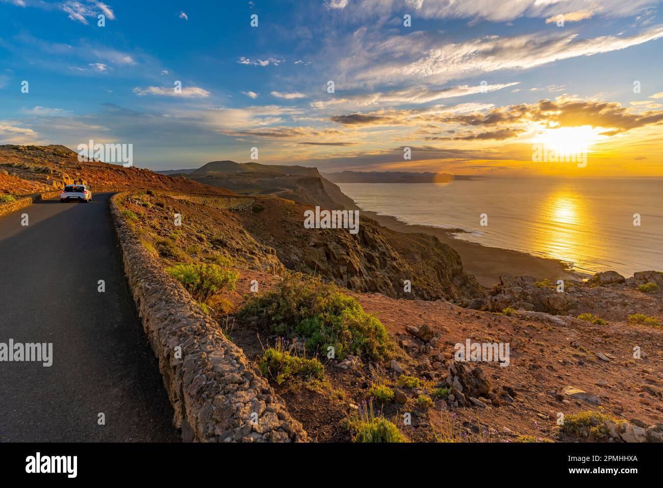 Blick auf Straße und vulkanische Küste von Mirador del Rio bei Sonnenuntergang, Lanzarote, Las Palmas, Kanarische Inseln, Spanien, Atlantik, Europa Stockfoto