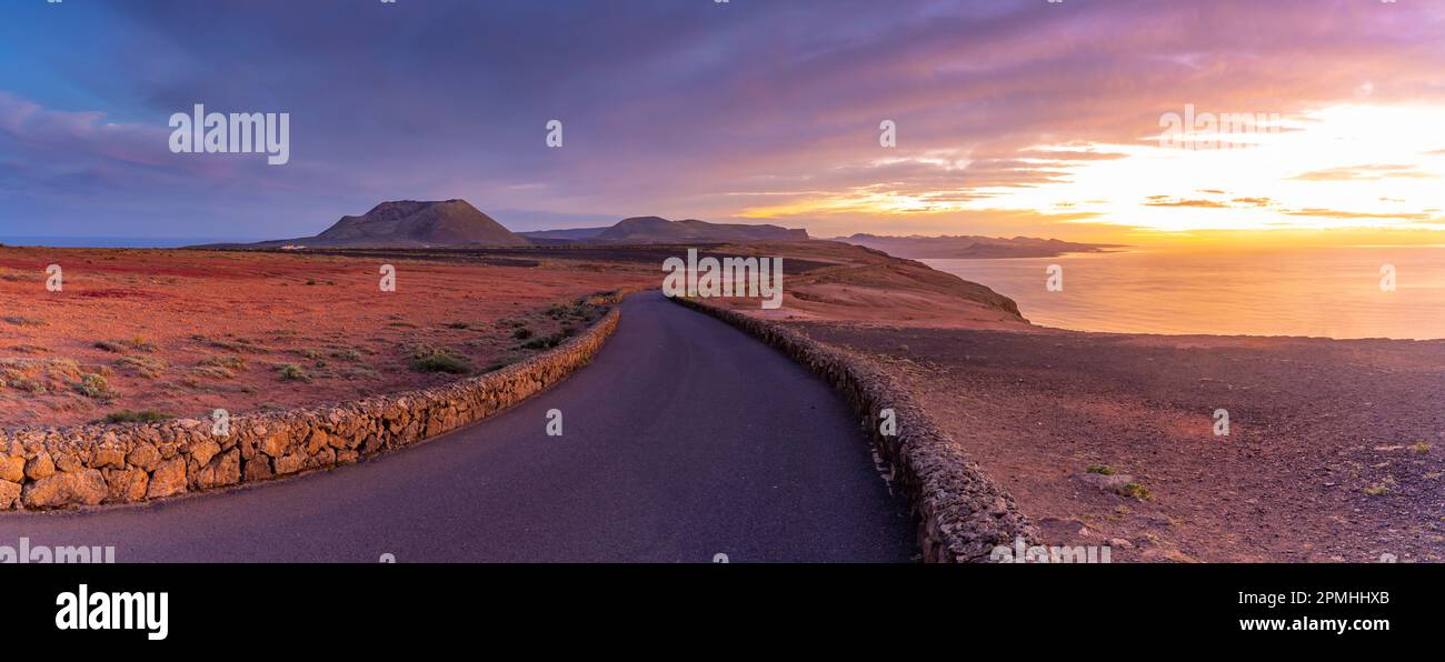 Blick auf Straße und vulkanische Küste von Mirador del Rio bei Sonnenuntergang, Lanzarote, Las Palmas, Kanarische Inseln, Spanien, Atlantik, Europa Stockfoto