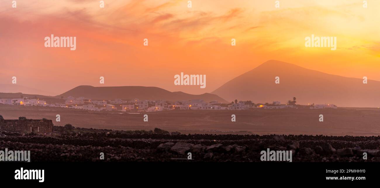 Blick auf Tinajo und Berge im Hintergrund bei Sonnenuntergang, Tinajo, Lanzarote, Las Palmas, Kanarische Inseln, Spanien, Atlantik, Europa Stockfoto
