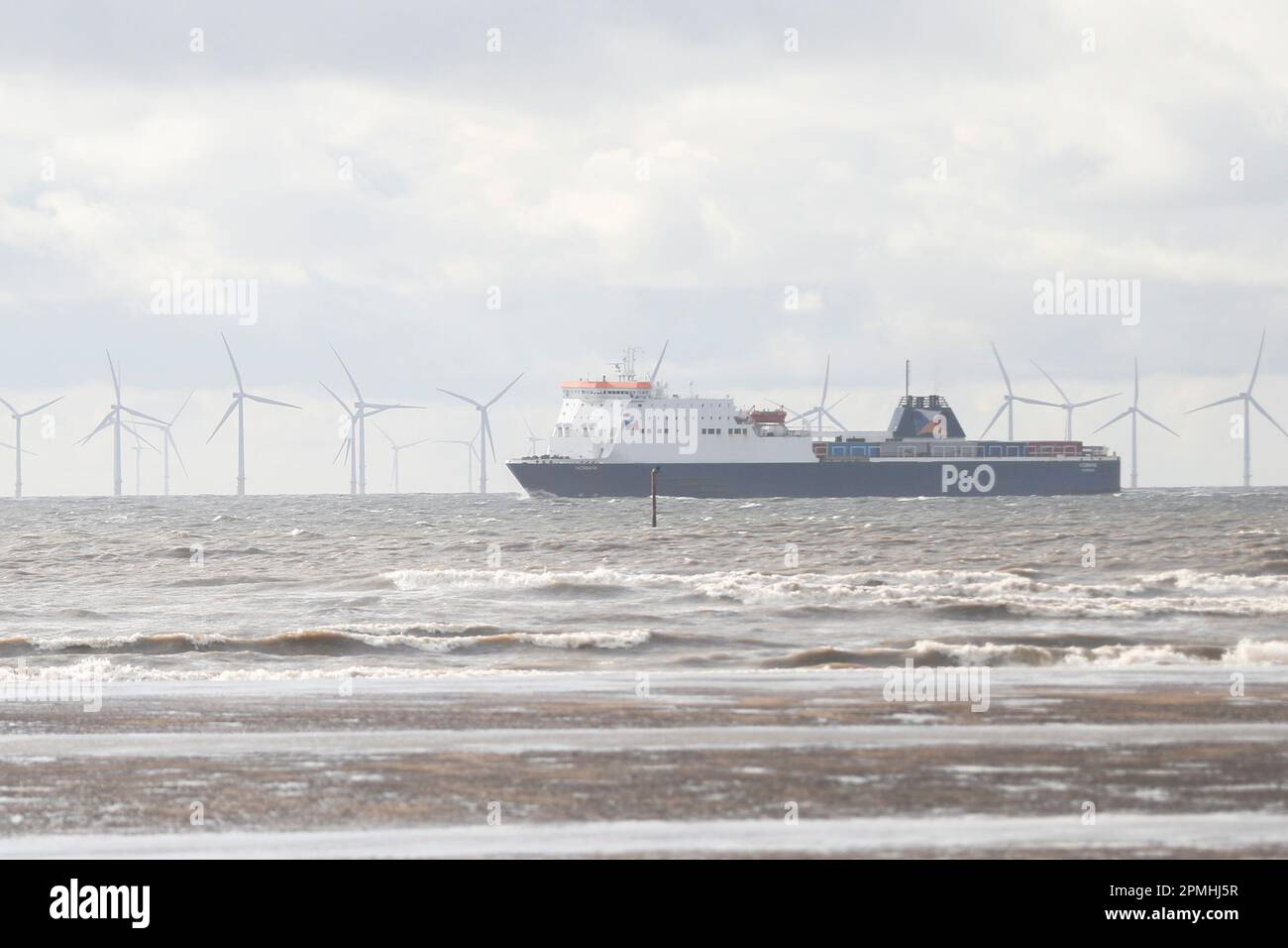 Crosby, Großbritannien. Die Iron Men at Crosby Beach blicken über die Burbo Bank Offshore Wind Farm vor der Küste von Merseyside Stockfoto