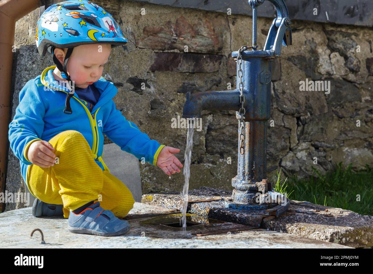 Ein Junge, der mit einer Wasserpumpe spielt Stockfoto