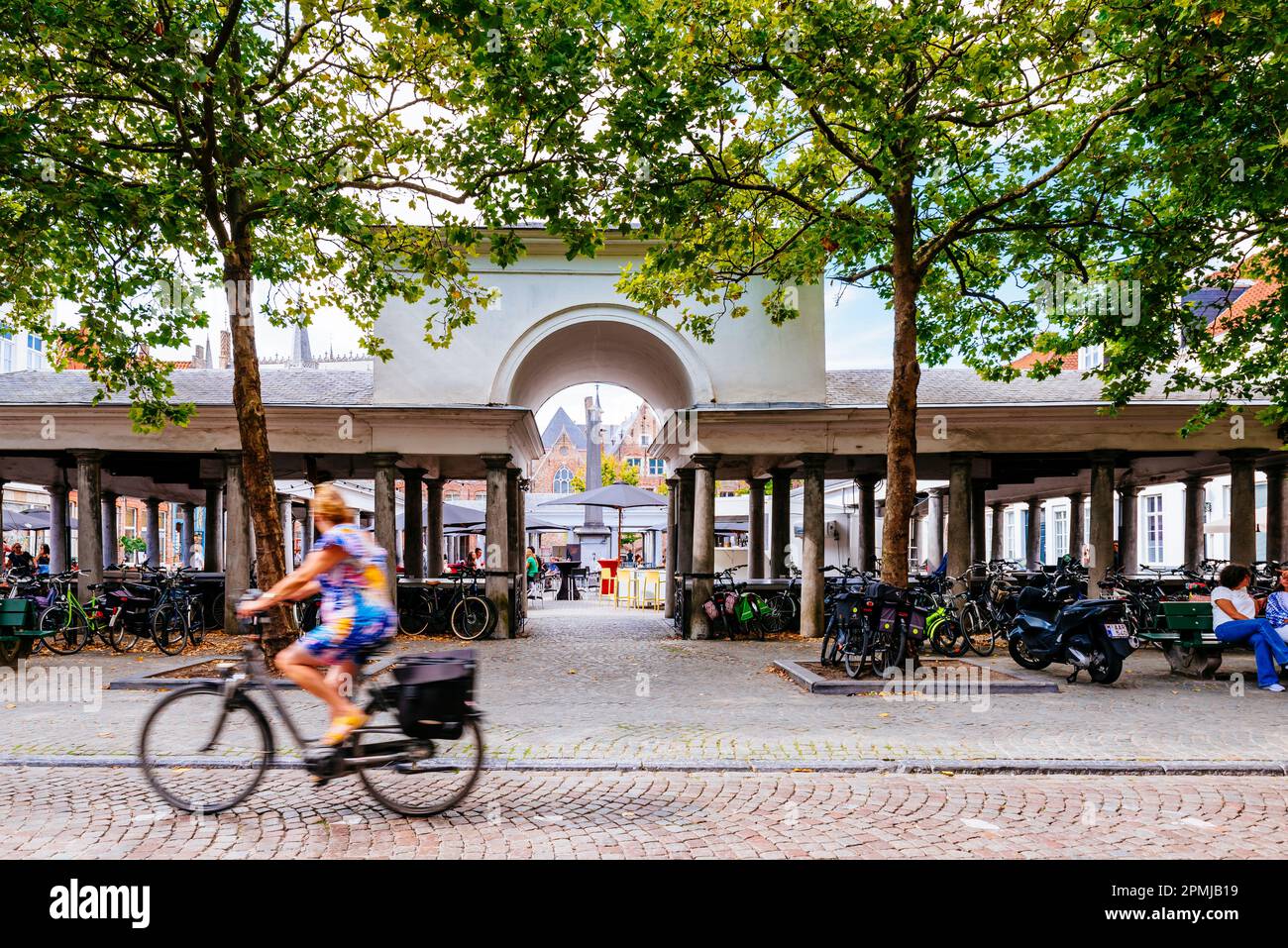 Frau, die mit dem Fahrrad neben dem Vismarkt fährt, Fischmarkt. Der Architekt Jean-Robert Calloigne entwarf eine klassische Kolonnade, die heute als OL gilt Stockfoto