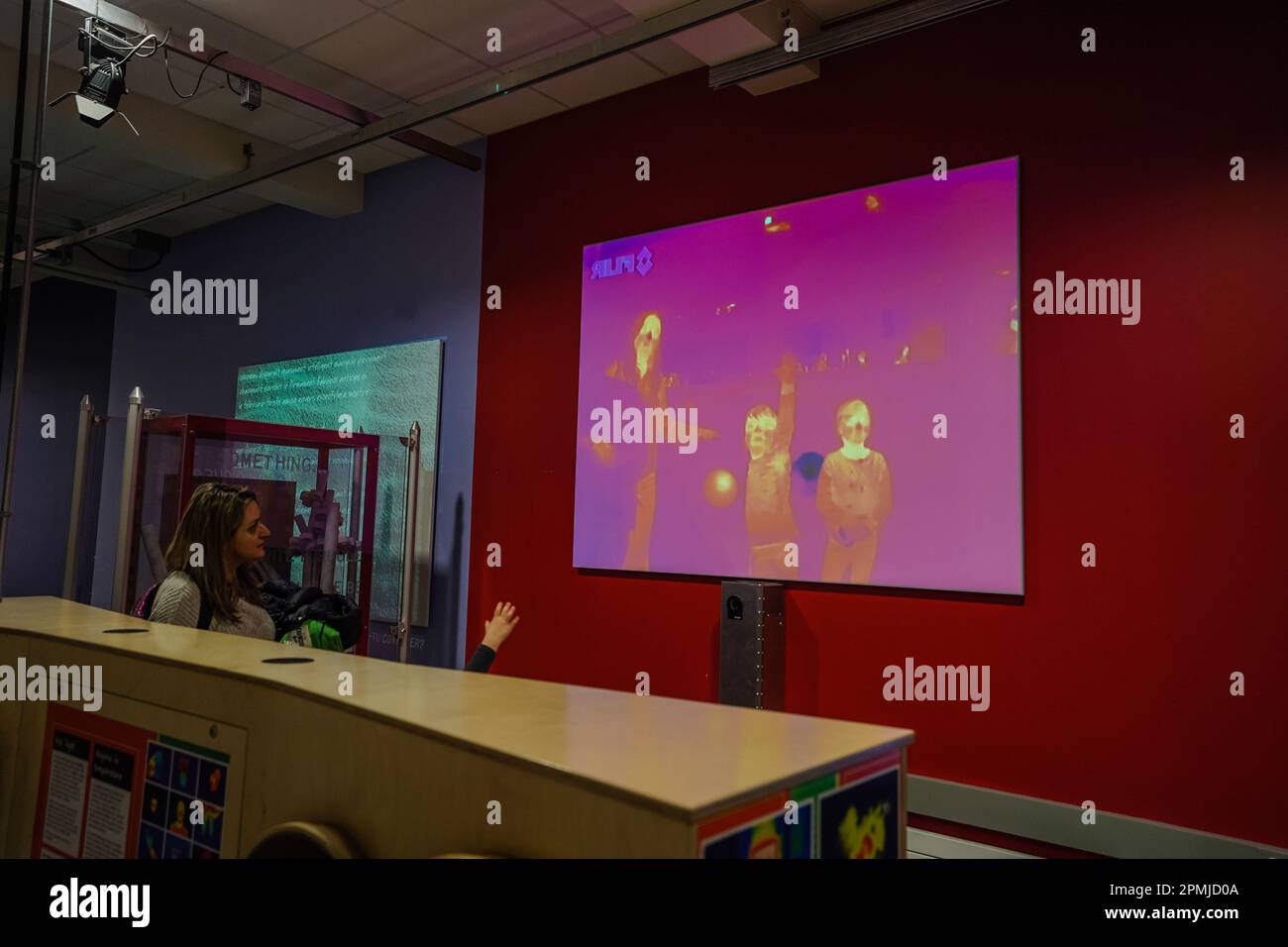 Wärmebildkarte der Infrarotkamera, die auf den Bildschirm projiziert wird und die Körpertemperatur der Personen anzeigt, die vor dem Bildschirm stehen Stockfoto