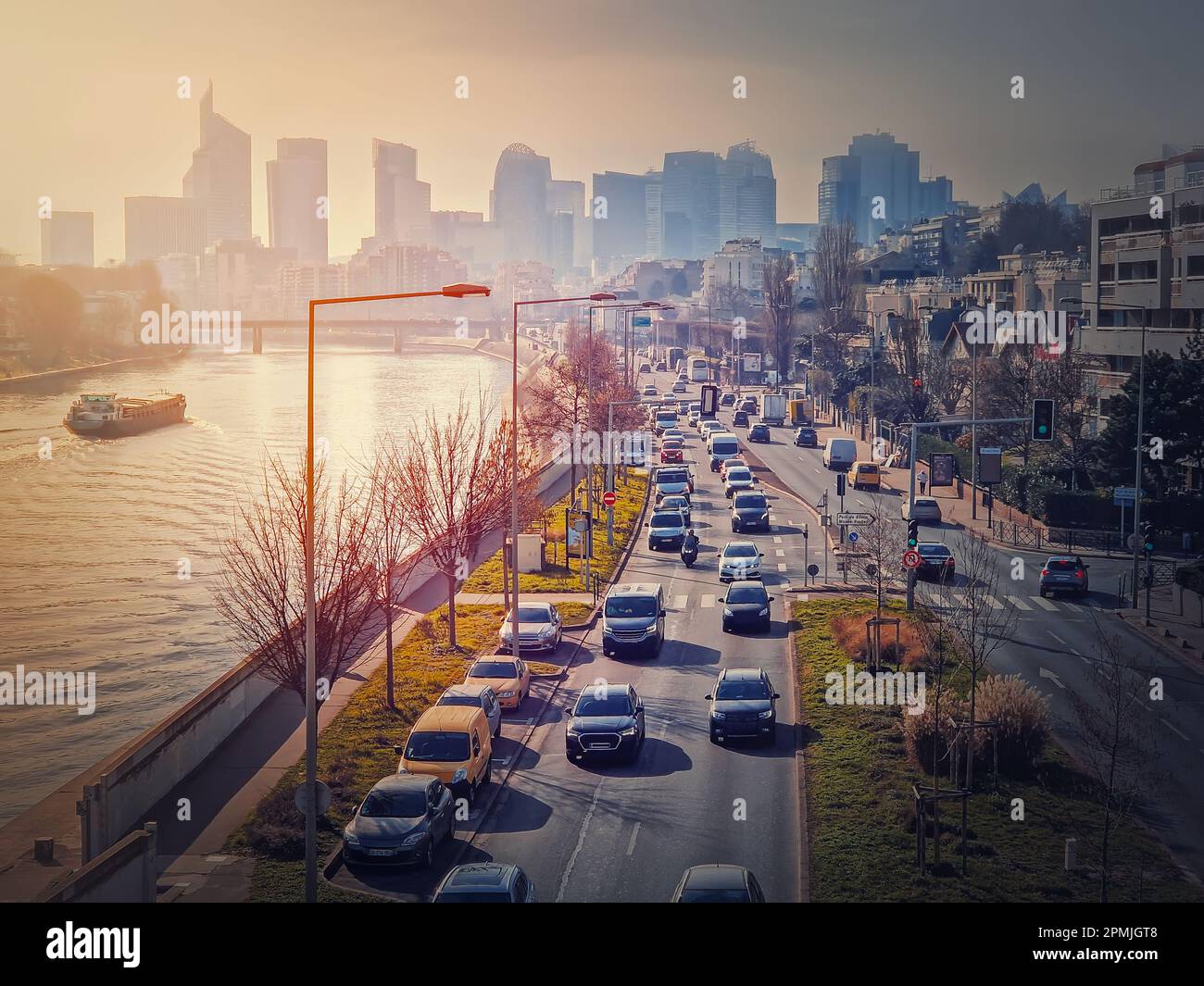 Viel Verkehr auf der Autobahn und den Straßen der Stadt verursacht hohe Umweltverschmutzung und Smog. Blick auf den urbanen Sonnenuntergang über die seine zum Stadtviertel La Defense, P Stockfoto