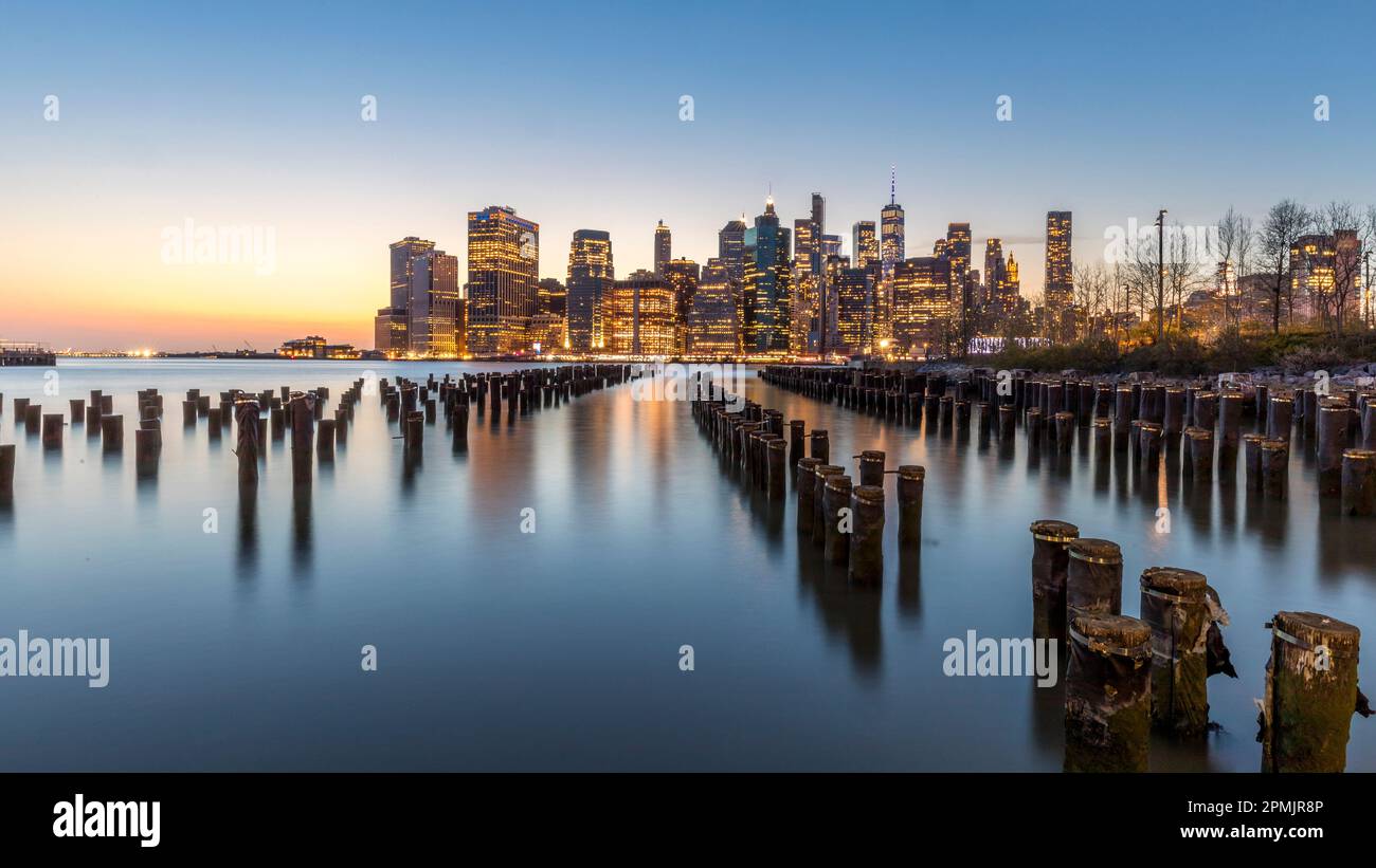 New York, USA - 25. April 2022: Lower Manhattan und ein alter Brooklyn Pier in der Abenddämmerung Stockfoto