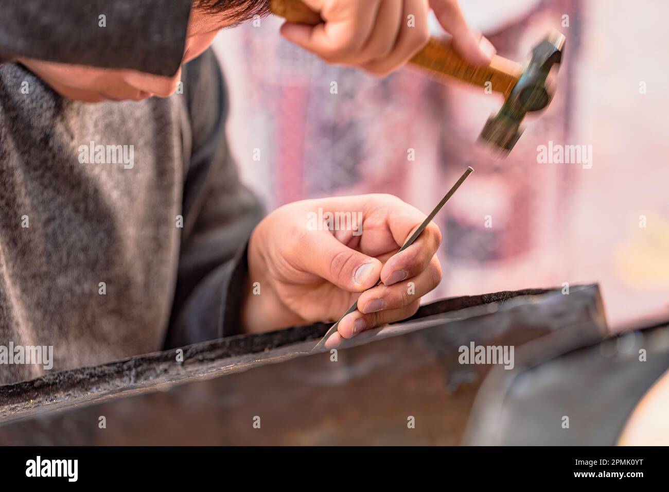 Ein Gravurmuster auf dem Metalltablett, Straßenwerkstatt. Samarkand, Usbekistan Stockfoto