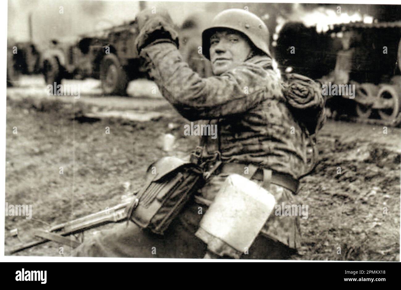 World war Two B&W Foto Ein deutscher Soldat macht während der Ardennenoffensive 1945 Fortschritte . Der Mann ist aus der 1. SS Panzer Division, gekleidet in einer Dot Camo Jacke, bewaffnet mit einem Angriffsgewehr Stg44 Stockfoto