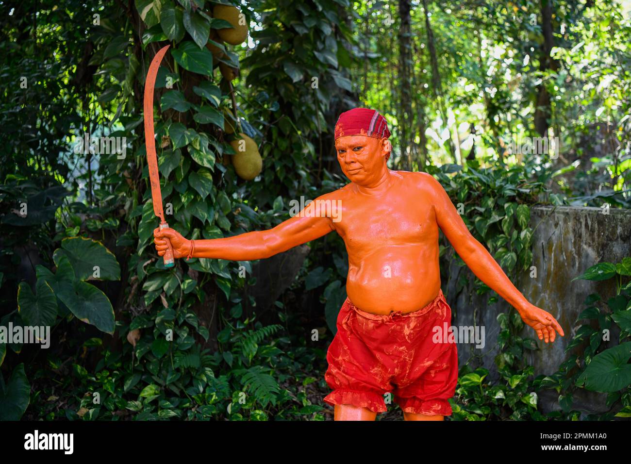 Porträt eines Hindu-Anhängers, der am letzten Tag des Bangla-Monats am Stadtrand von Dhaka in Munshigonj an einem Festival namens Lal Kach (Rotes Glas) teilnimmt. Das Festival ist der Verehrung von Lord Shiva und Parvati gewidmet. Es wird angenommen, dass eine Gruppe von Soldaten unter Shiva auf der Erde auftaucht, mit der Mission, die Mächte des Bösen abzuwehren. Diese Soldaten, die im göttlichen Licht Shivas leuchten, marschieren zu nahe gelegenen Tempeln. Das alles ist Teil einer sehr langen Tradition, die Hunderte von Jahren zurückreicht. Die Hindus, vor allem die Jungen, malen sich rot an, nehmen Schwerter und holen Prozessi heraus Stockfoto