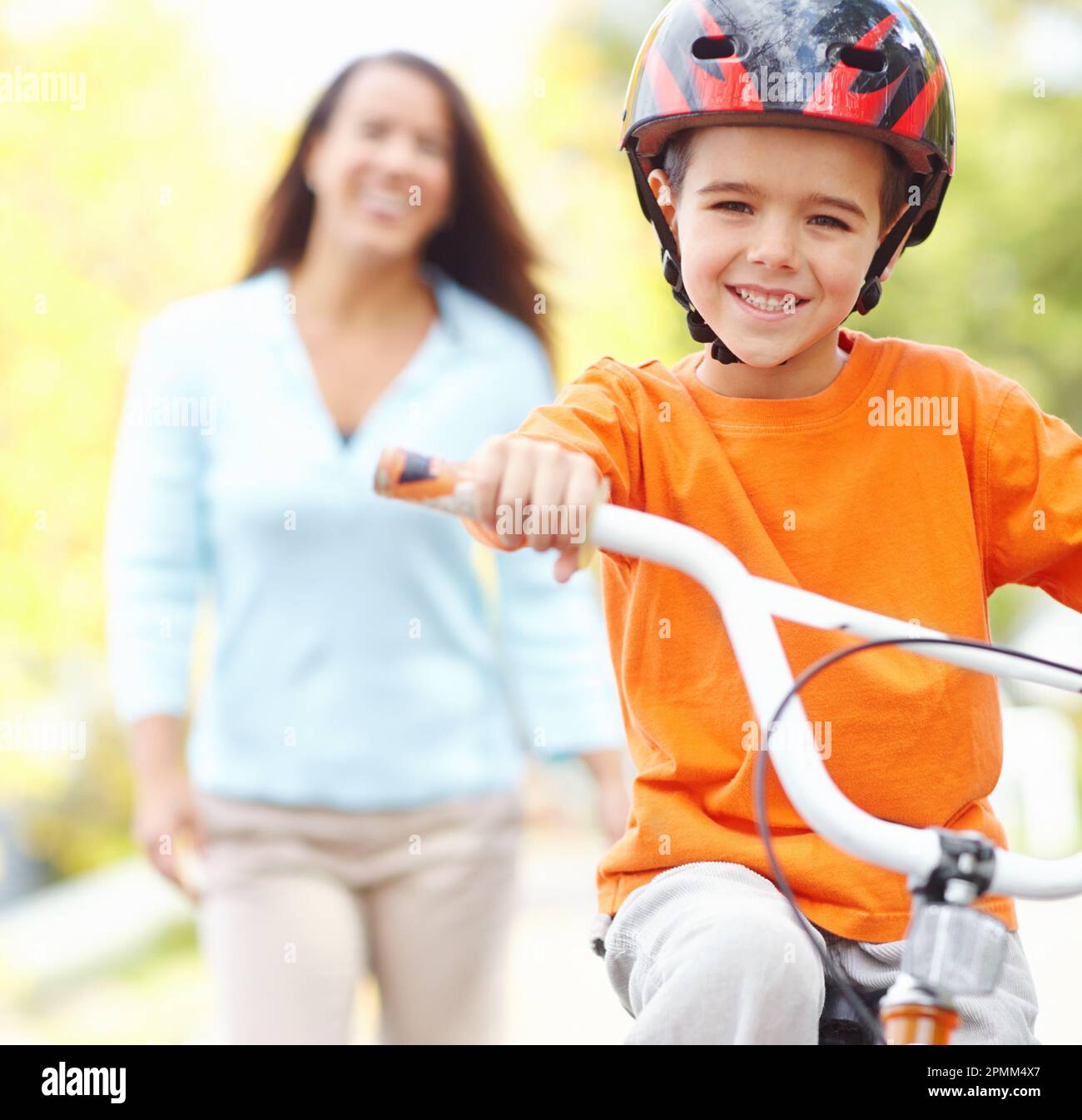 Ich schaffe das. Bild eines kleinen Jungen, der zum ersten Mal Fahrrad fährt. Stockfoto