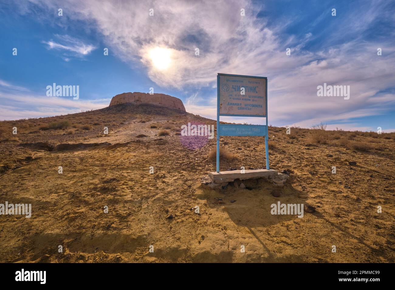 Die dramatische Aussicht vom Fuß des Ortes, mit Schild für den alten Pfad nach oben. In Chilpik, dem heiligen Grabhügel der Zoroastrien in der Nähe von Nukus, Karakalpaks Stockfoto