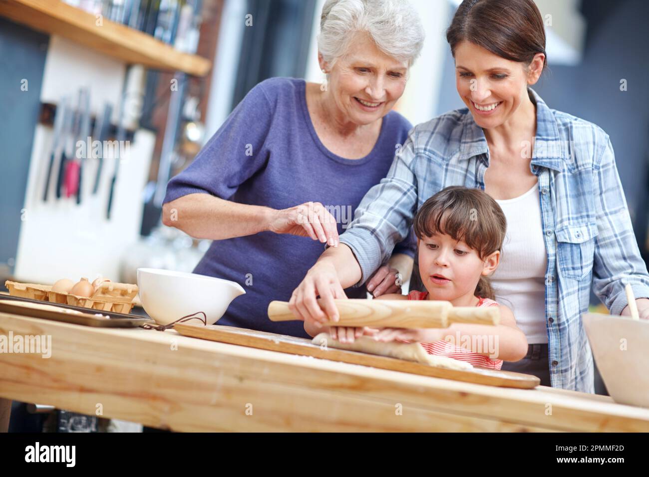Glück ist hausgemacht. Eine dreigenerationale Familie, die zusammen backt. Stockfoto