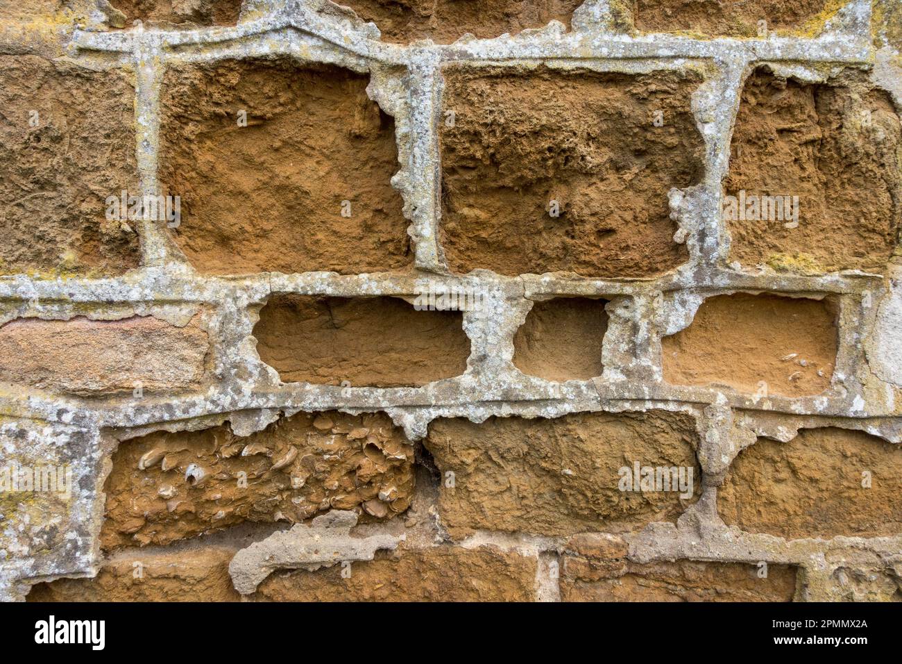 Durch Wasser beschädigte, verwitterte, erodierte Mauerwand aus Kalkstein am Straßenrand Stockfoto