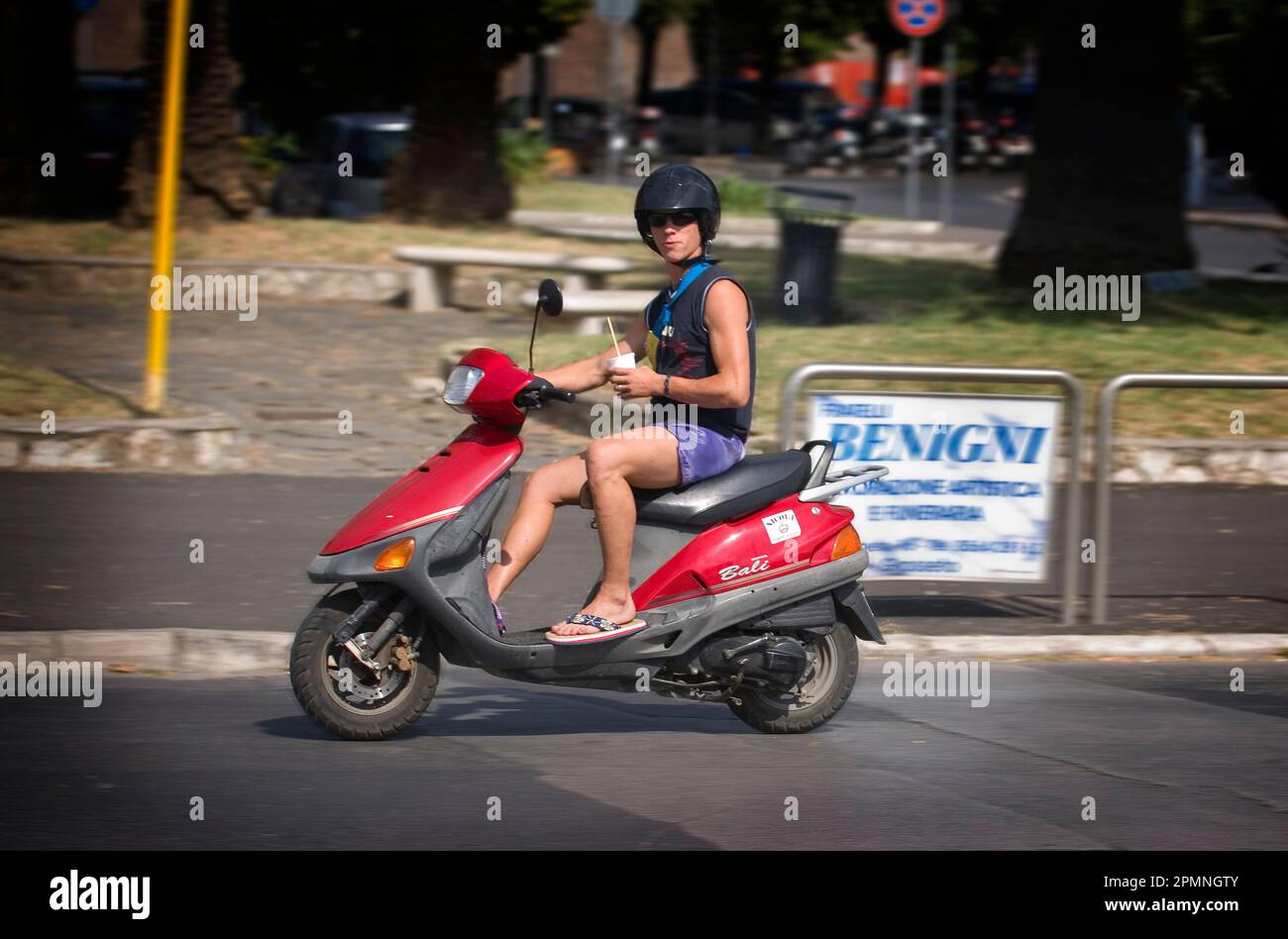 Grosseto, Italien, 23.07.2010. Ein Mann auf einem Roller, der durch die Stadt fährt. Stockfoto