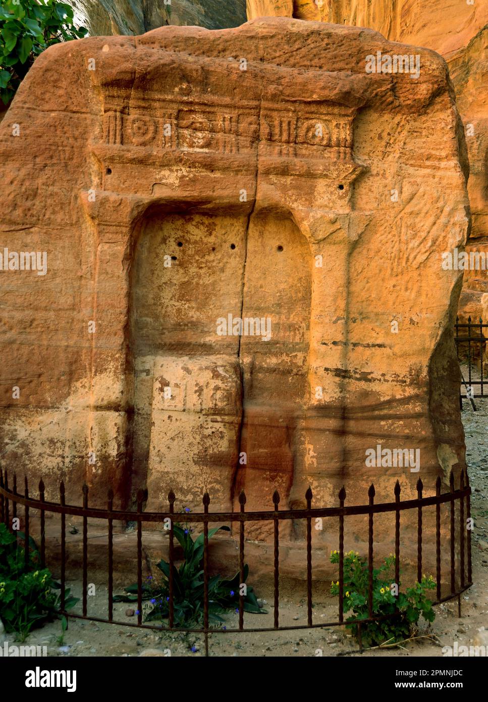 Monumentale in den Fels gehauene Fassade des Palastgrabes entlang der zerklüfteten Sandsteinklippen des Royal Tombs unter einem klaren blauen Himmel Petra, Jordanien Stockfoto