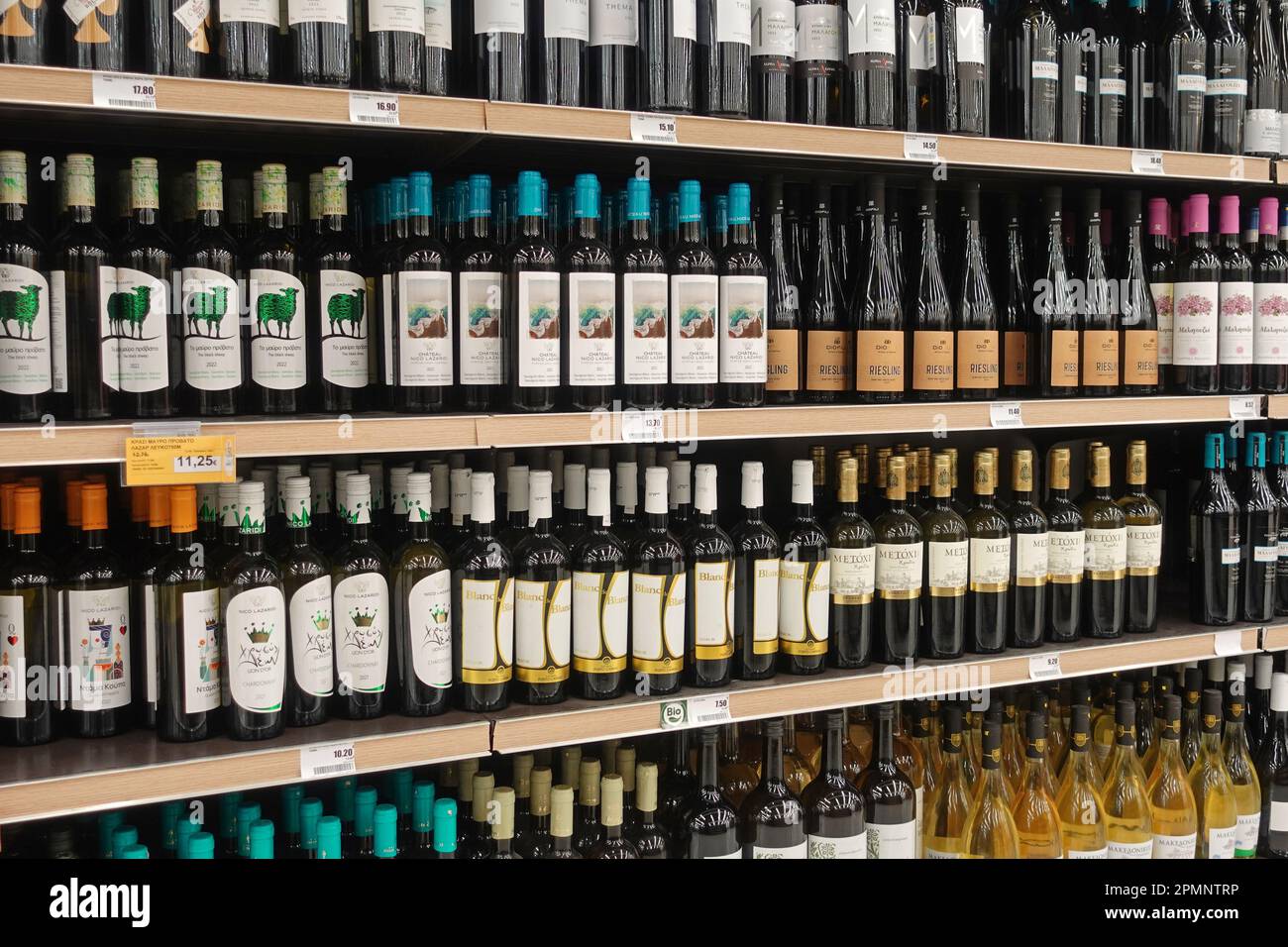 Athen, Griechenland - 6. März 2023: Rot- und Weißwein Alkohol Getränke Flaschen auf Spirituosenregalen. Stockfoto
