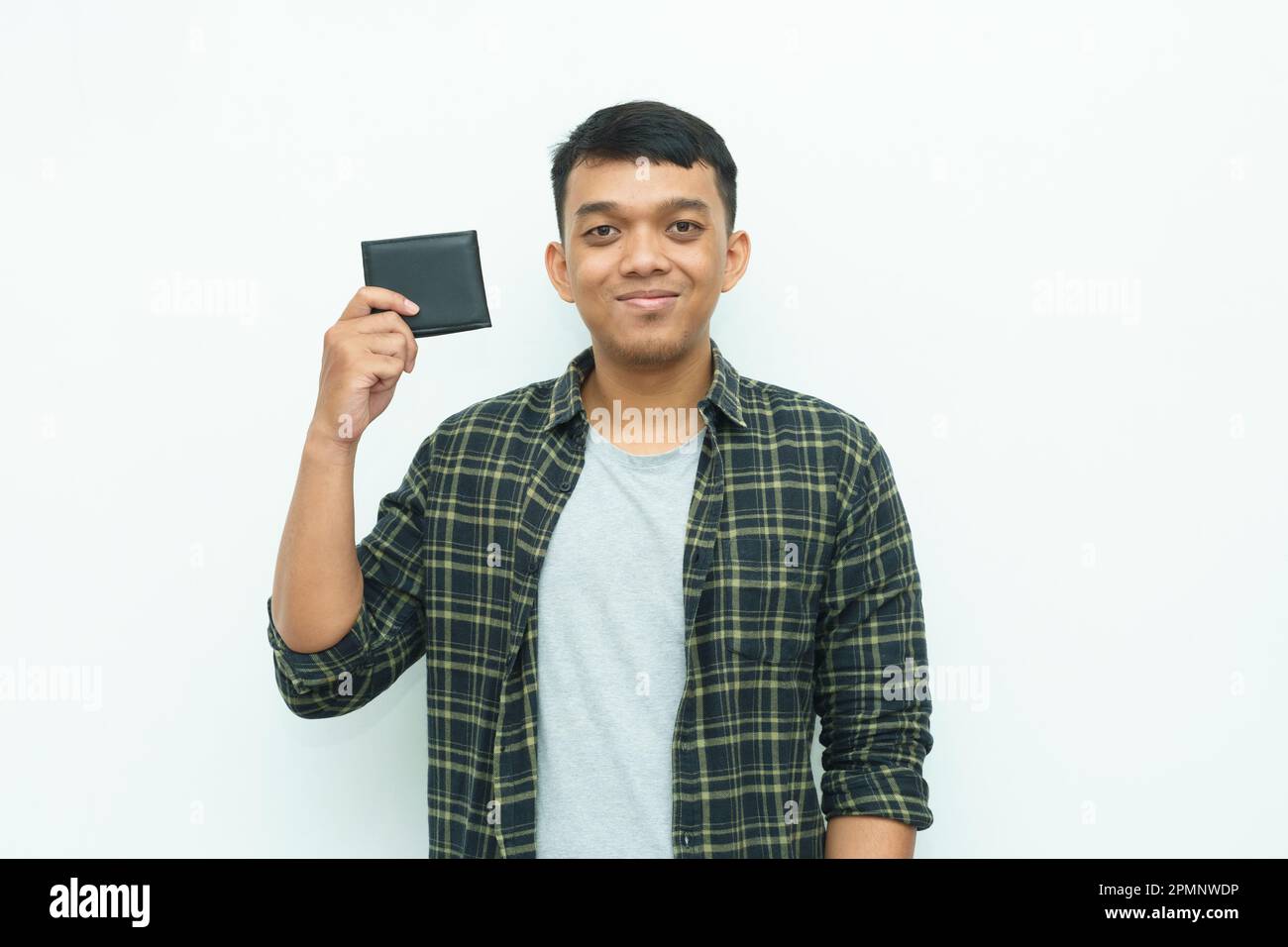 Ein junger asiatischer Mann lächelt, während er die schwarze Brieftasche in der Hand hält Stockfoto