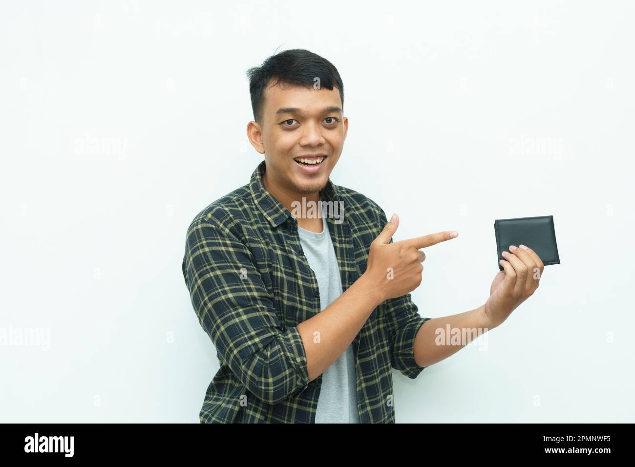 Ein junger asiatischer Mann, der lächelt, während er auf die schwarze Brieftasche zeigt Stockfoto