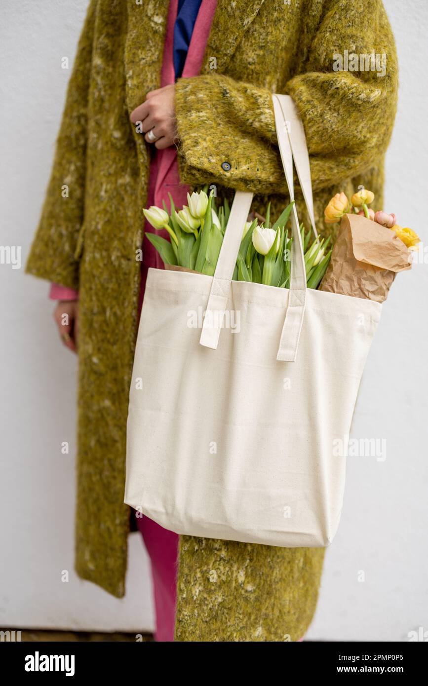 Tragetasche mit Blumen halten Stockfoto