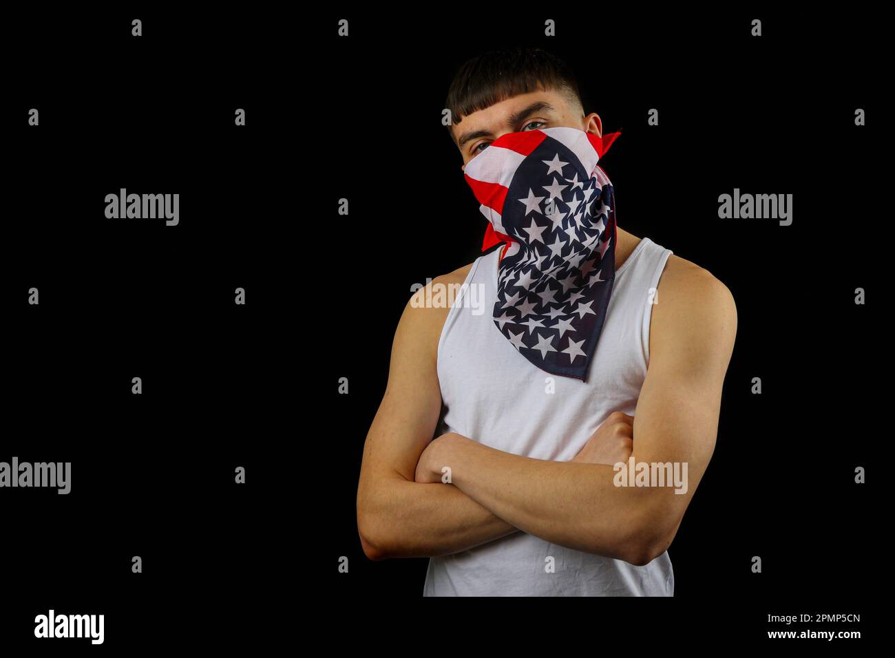 Teenager in einer weißen Weste mit einer American Flag Maske auf schwarzem Hintergrund Stockfoto