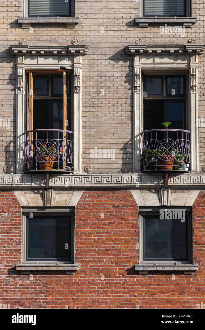 Dekorative Balkone in einem Wohngebäude. Das schmiedeeiserne Geländer mit roten Geranien sorgt für eine schöne urbane Umgebung Stockfoto