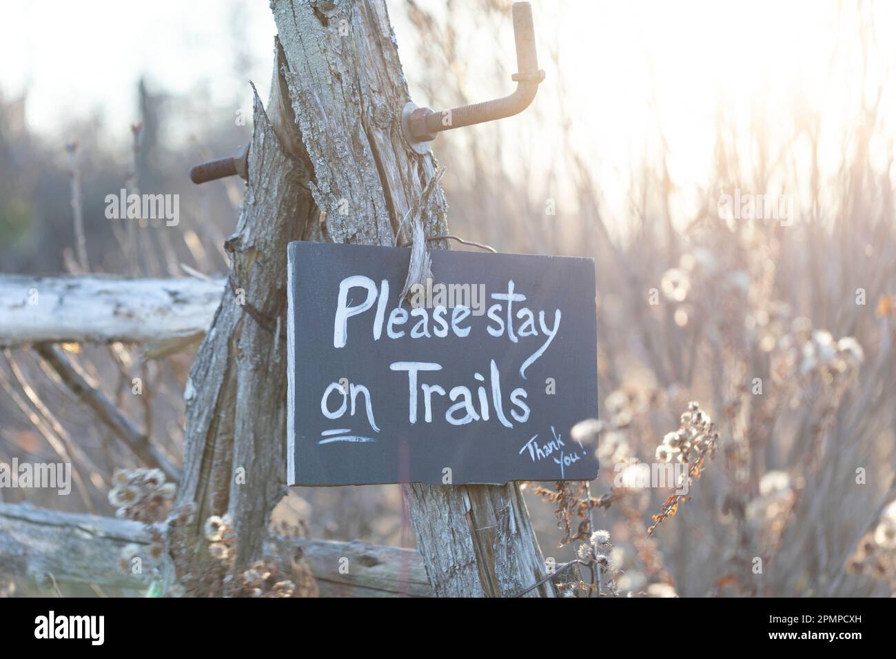 Ein Schild hängt an einem verwitterten Pfosten und bittet Wanderer, auf dem Pfad zu bleiben; Ottawa Valley, Ontario, Kanada Stockfoto