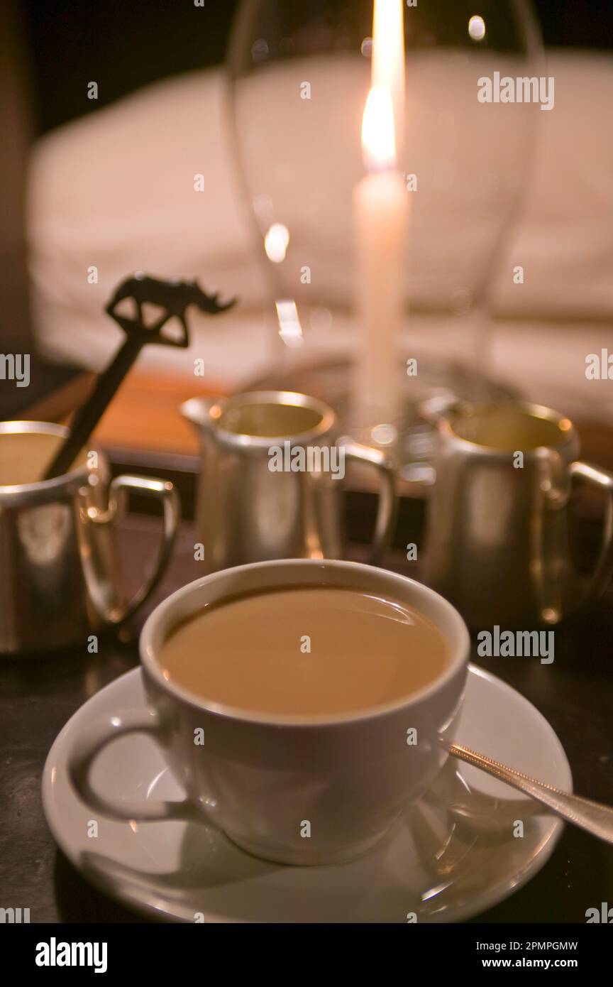 Eine Tasse Tee neben einer Laterne mit Kerzenlicht, Masai Mara National Park; Kenia Stockfoto